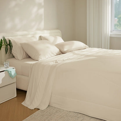 Breescape cooling sheet set in cream on a bed, featuring soft fabric and pillows.