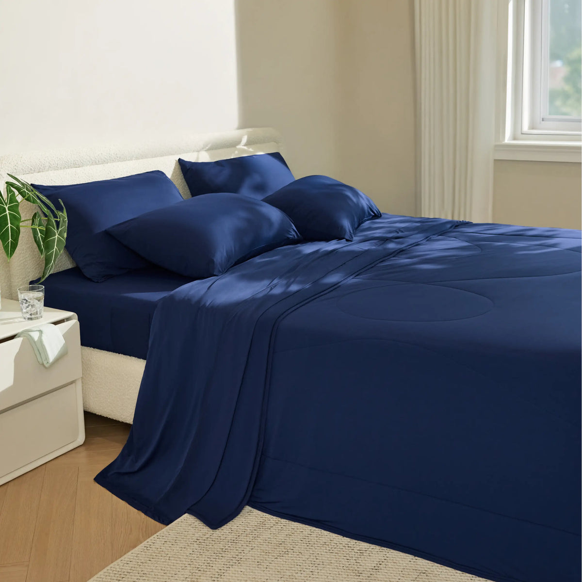 Twilight blue Breescape cooling sheets and comforter on a bed, showcasing plush texture and smooth fabric.